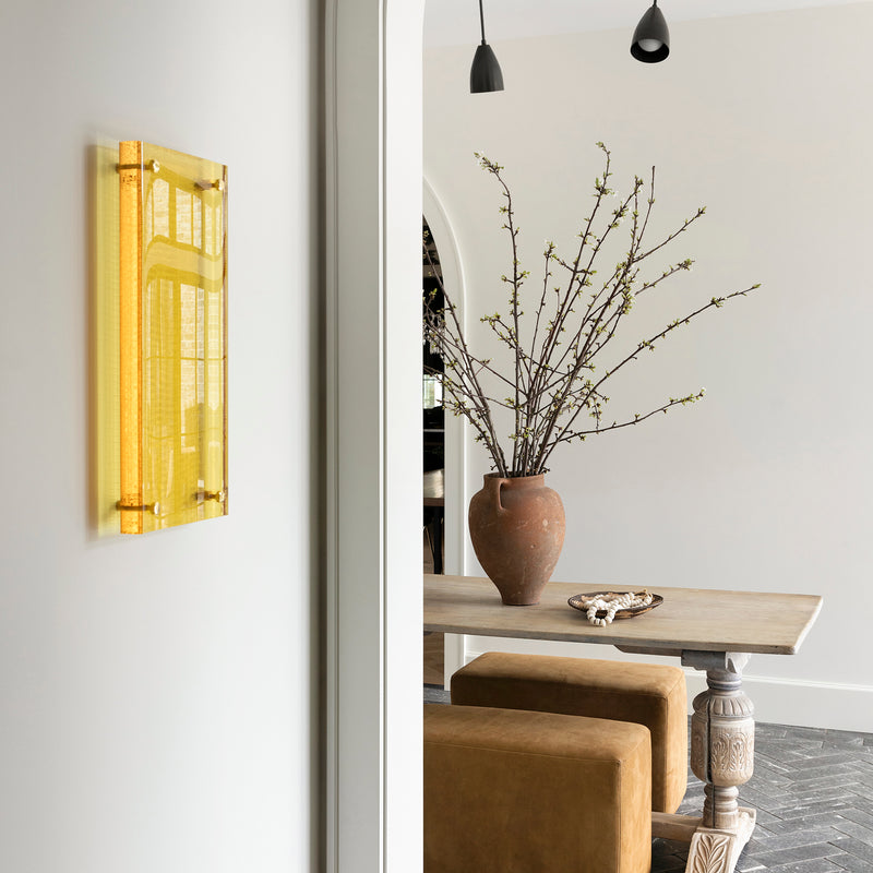 An informal sitting area with an antique table, modern pendants, and textural bench seating by Nate Berkus.