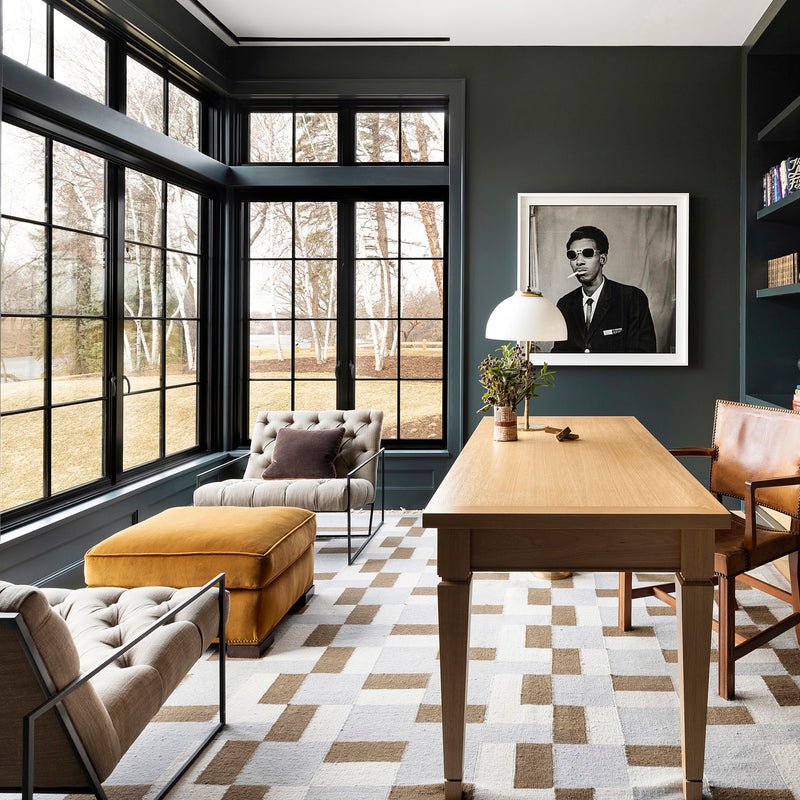 An office by Nate Berkus Associates, with deep green walls, built-ins, modern pendants, statement art, and art, and a classic wooden desk.