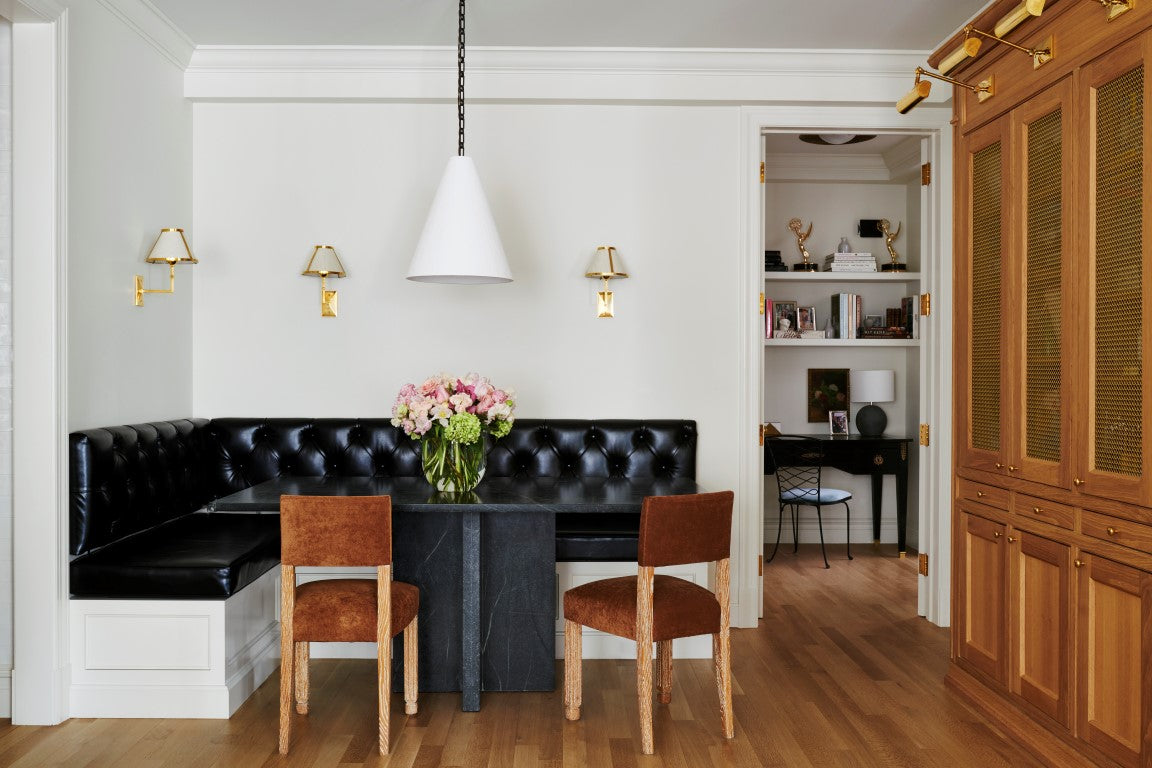 Dining nook with black leather banquette, two French oak and velvet side chairs, and an oak built-in bookcase. 