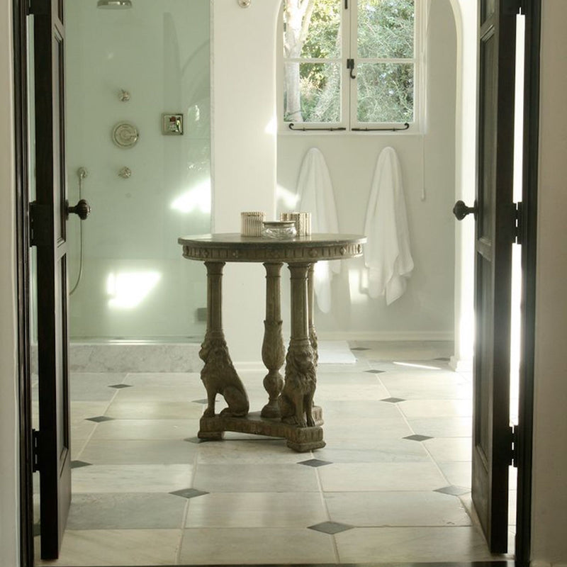 A textural white-on-white bathroom by Nate Berkus Associates featuring arched entries and natural stone.