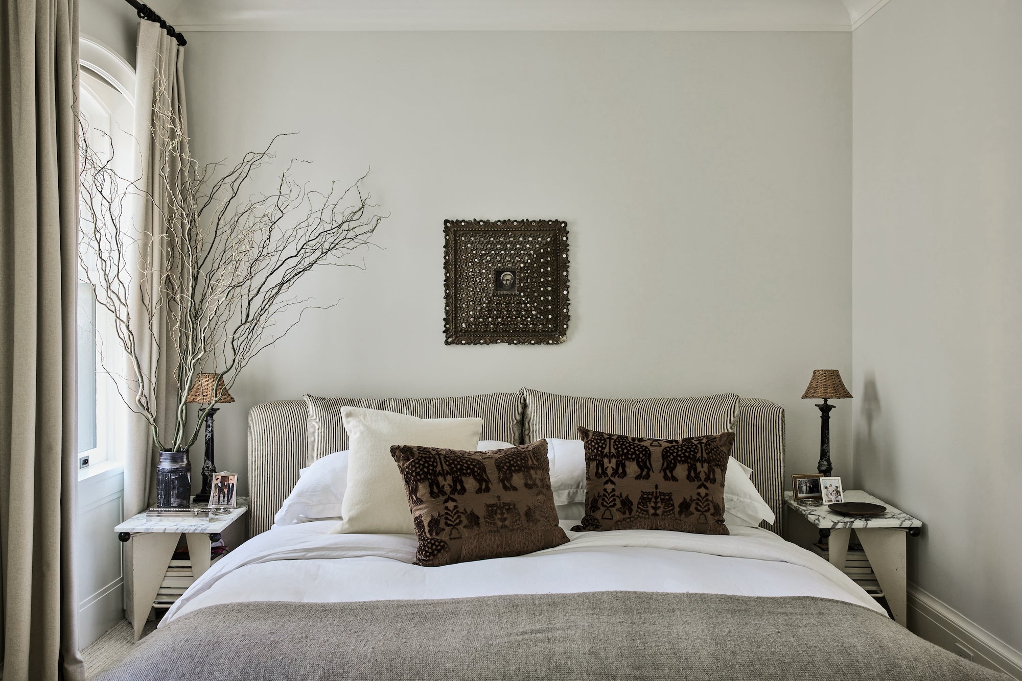 A tonal and textural primary bedroom, featuring earthy hues and materials, designed by Nate Berkus and Jeremiah Brent.
