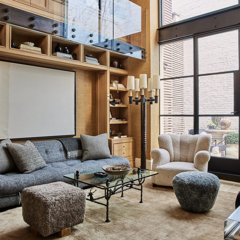 A West Village home living room with floor-to-ceiling built-ins and large-scale glass doors, designed by Nate Berkus and Jeremiah Brent.