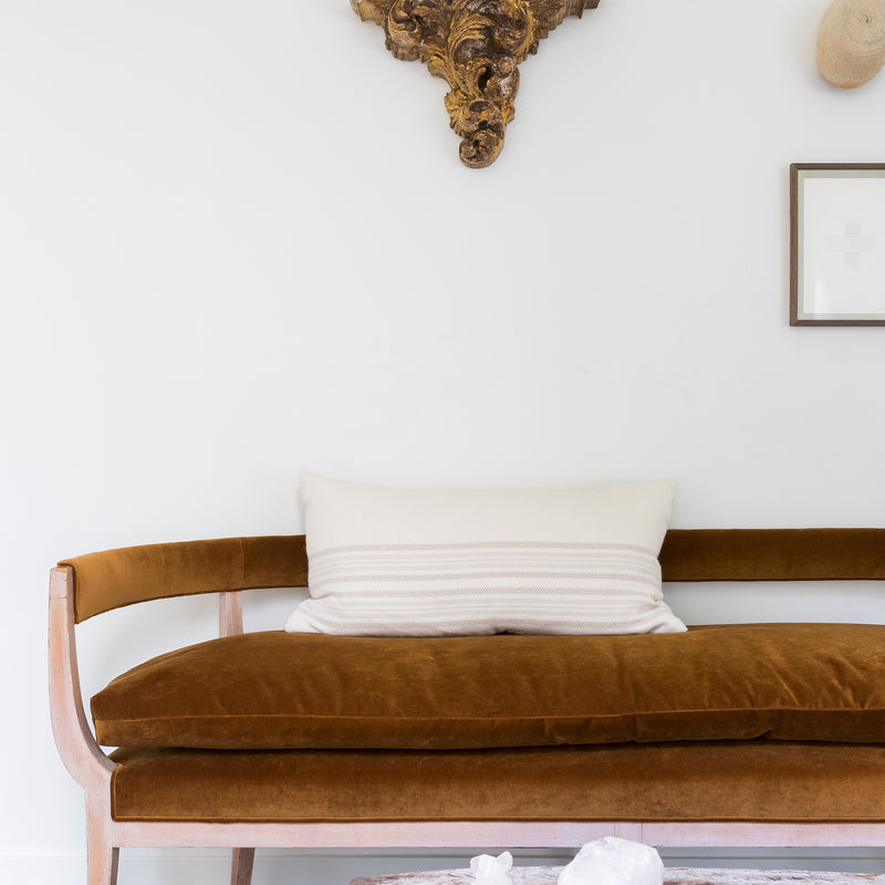 A rust-toned settee is right at home amid well-traveled finds in the entry way of the 1928 Spanish Bungalow restored and designed by Nate Berkus and Jeremiah Brent.