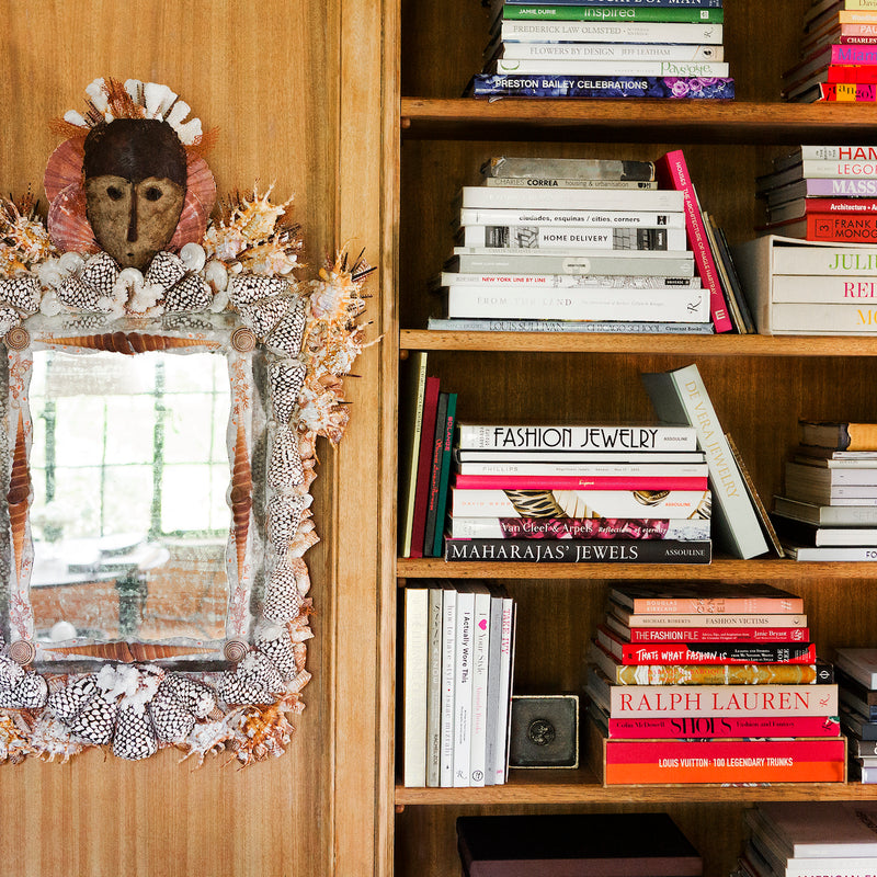 Unexpected and one-of-a-kind art pieces are found throughout this home designed by Nate Berkus and Jeremiah Brent, including this small mirror hung on the built-in bookshelves.