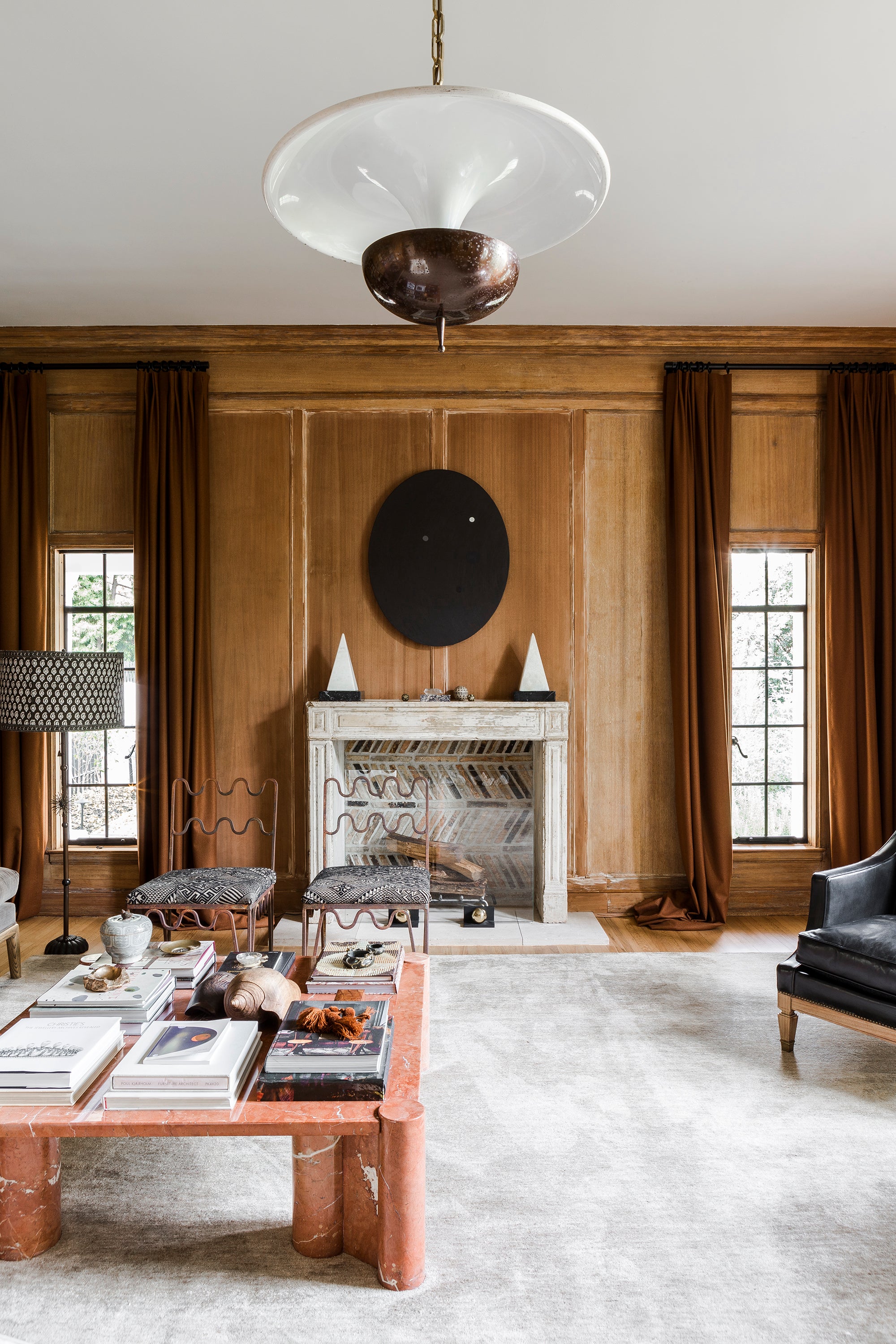 A wood-paneled living area of warm tones, clean lines, and collected furnishings by Nate Berkus and Jeremiah Brent.