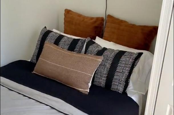 Load video: A time-lapse video showcasing Nate’s best tips for making a stylish bed by paring cozy auburn accent pillows with a classic black and white bedding set.
