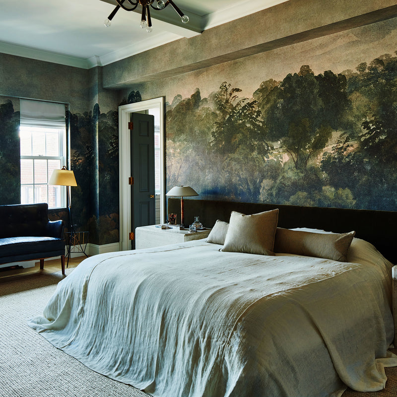 A moody and modern bedroom with landscape-inspired wallpaper and furnishings that feel lived-in yet refined.
