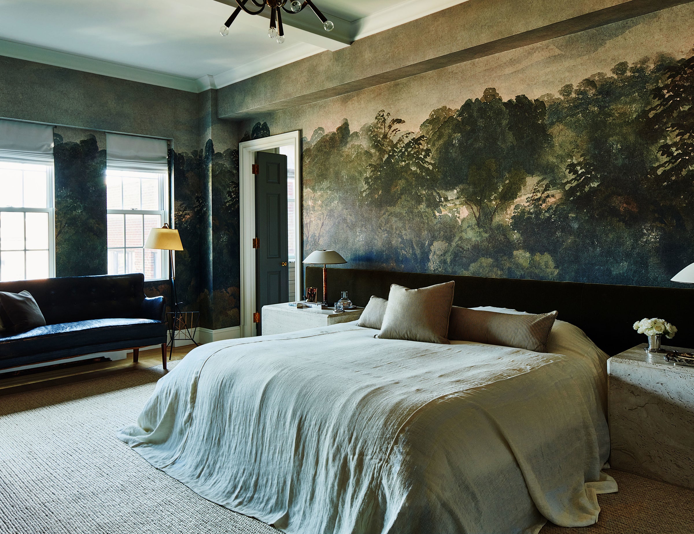 A moody and modern bedroom with landscape-inspired wallpaper and furnishings that feel lived-in yet refined.