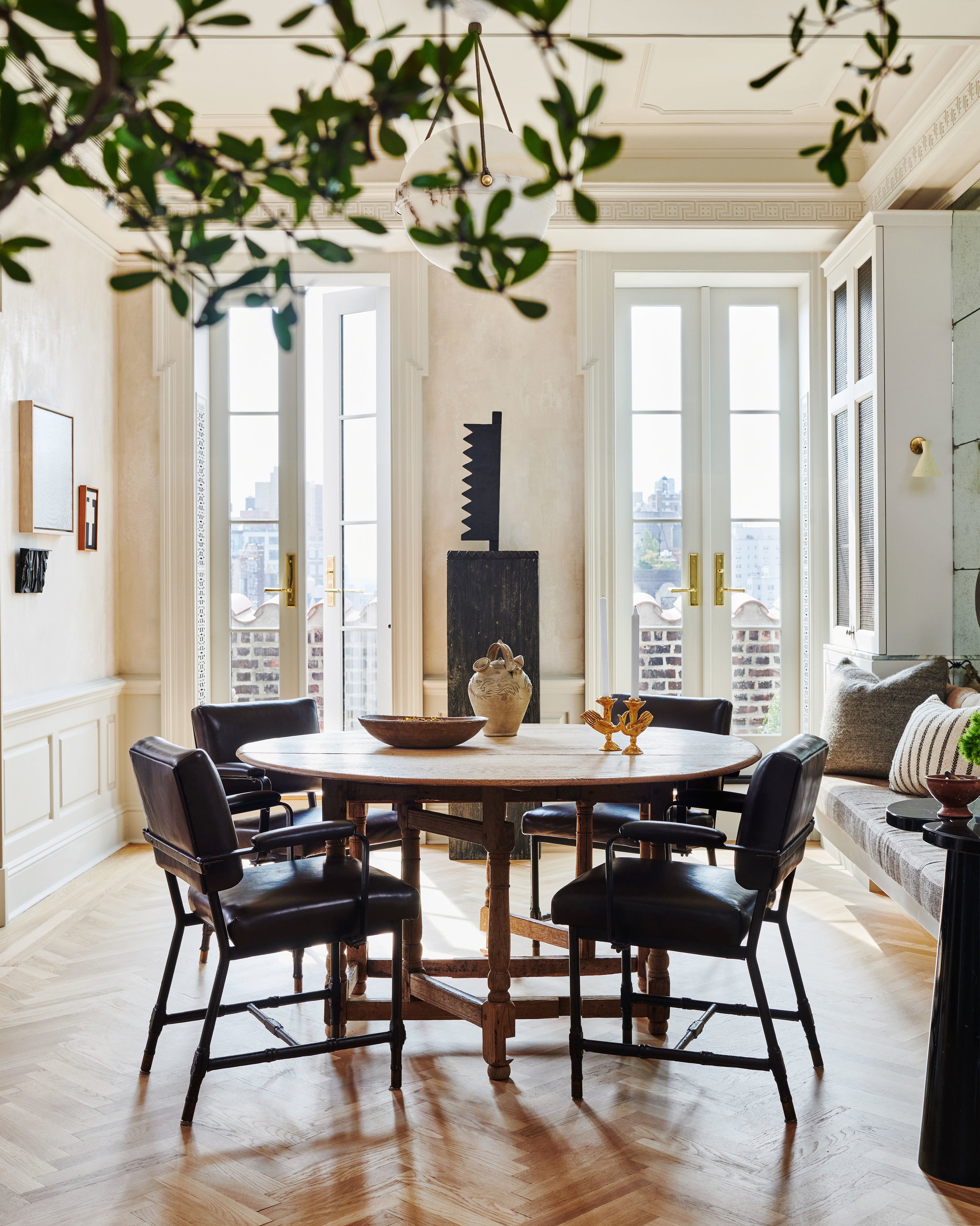 Natural light streams in through french doors in the dining nook of a Manhattan home, designed by Nate Berkus and Jeremiah Brent. 
