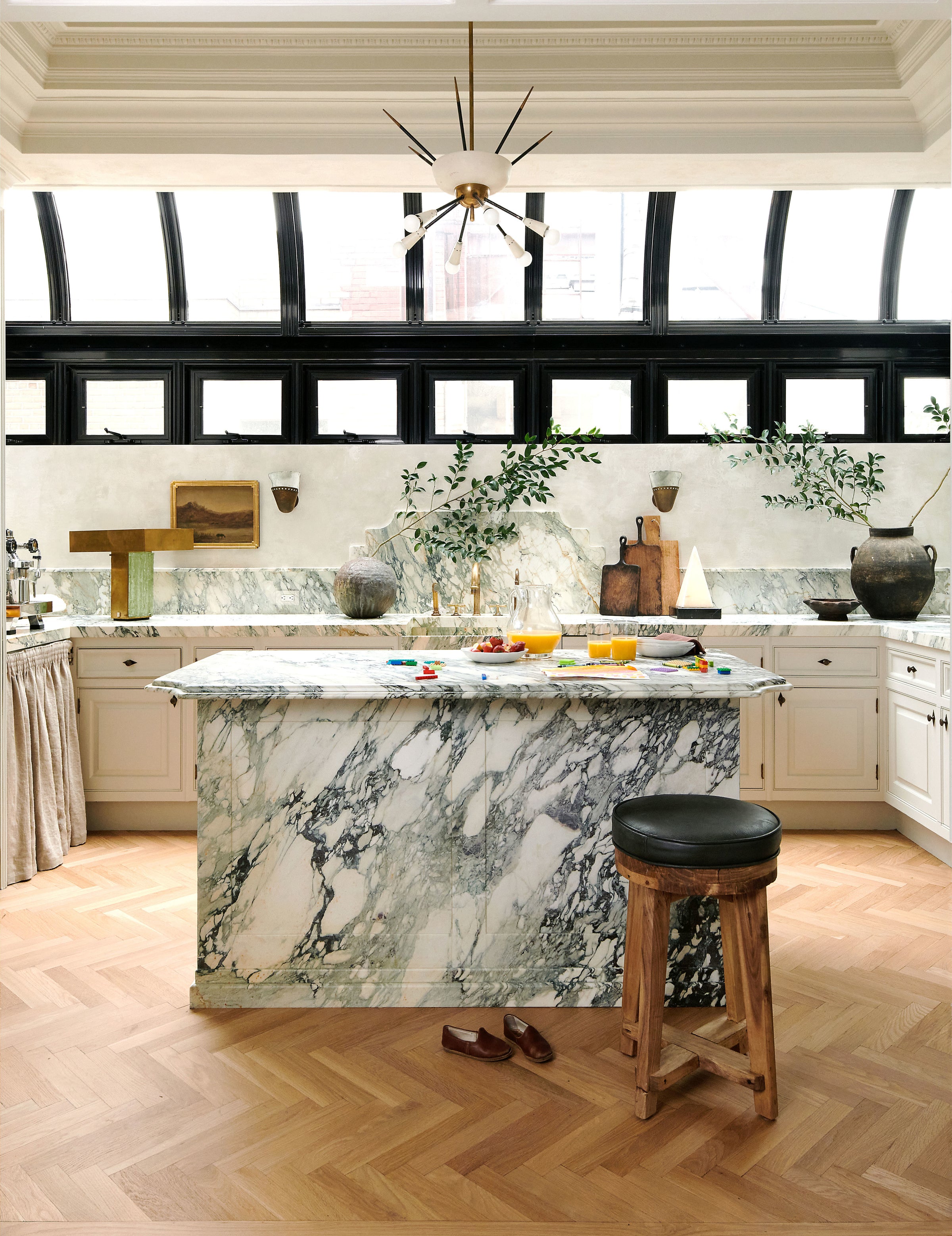 A marble-clad island is the focal point of this contemporary, organic kitchen by Nate Berkus and Jeremiah Brent.
