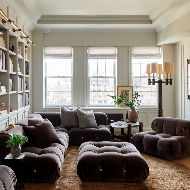 A family room designed for lounging, with monochromatic seating and built-in bookshelves, designed by Nate Berkus and Jeremiah Brent. 